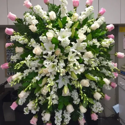 Gentle Journey Funeral Spray – Peaceful Floral Tribute featuring pink and white roses, lilies, and stock flowers.