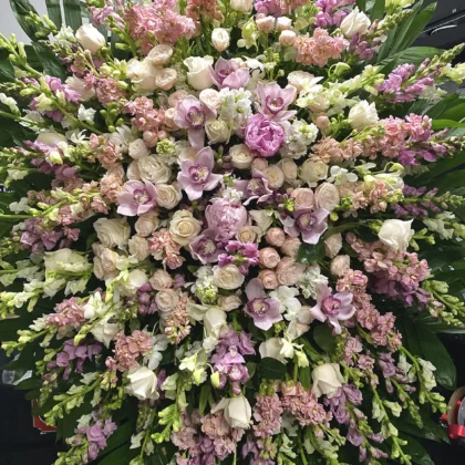 Pure Grace Funeral Spray – Elegant Floral Tribute featuring soft pink and white orchids, roses, and lush greenery.