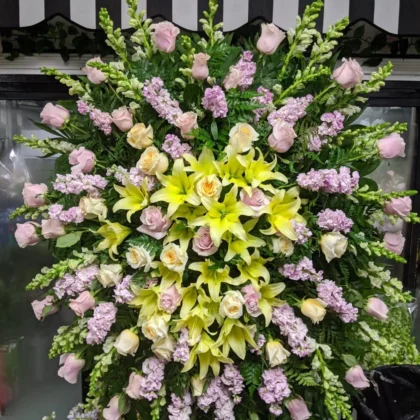 Quiet Comfort Funeral Spray - Stunning Design featuring soft pink roses, yellow lilies, and lavender stock flowers.