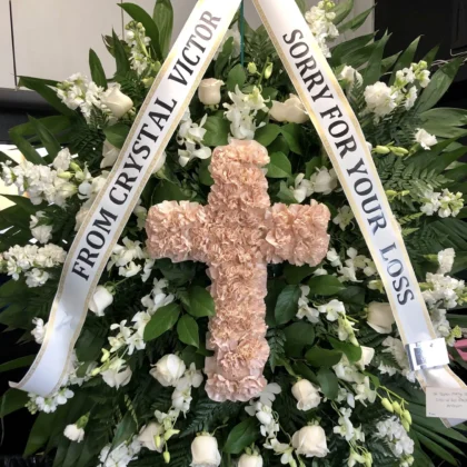 Cross My Heart - Funeral Spray featuring a soft peach carnation cross nestled in white roses and snapdragons.